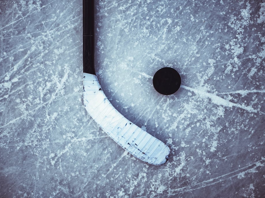 hockey puck and stick laying on the textured ice close up copyspace